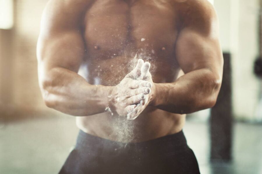 Cropped shot of an unrecognizable young man powdering his hands during a workout in the gym.